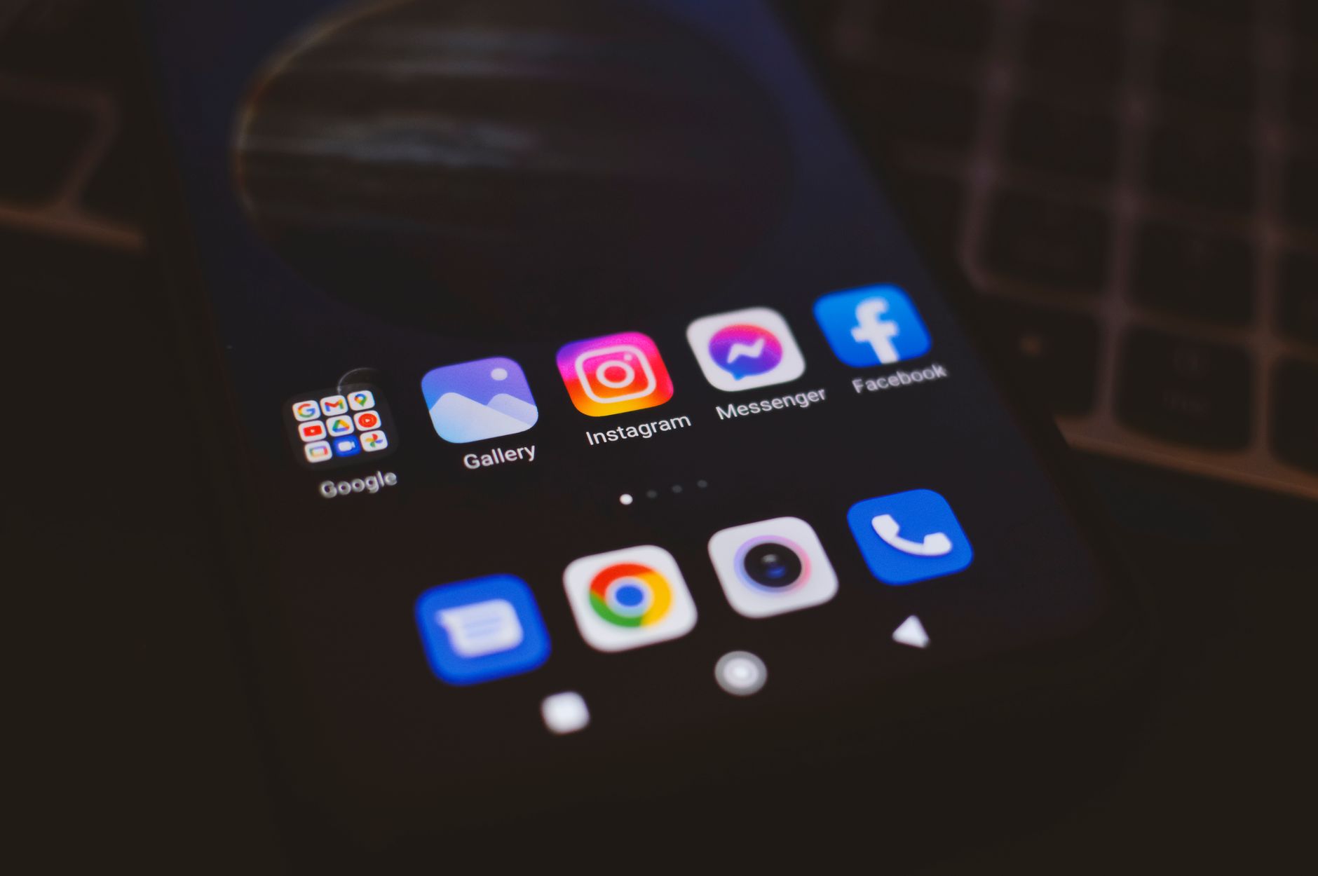 Un smartphone affichant des applications populaires de médias sociaux dans un environnement faiblement éclairé, idéal pour les thèmes technologiques et de communication.