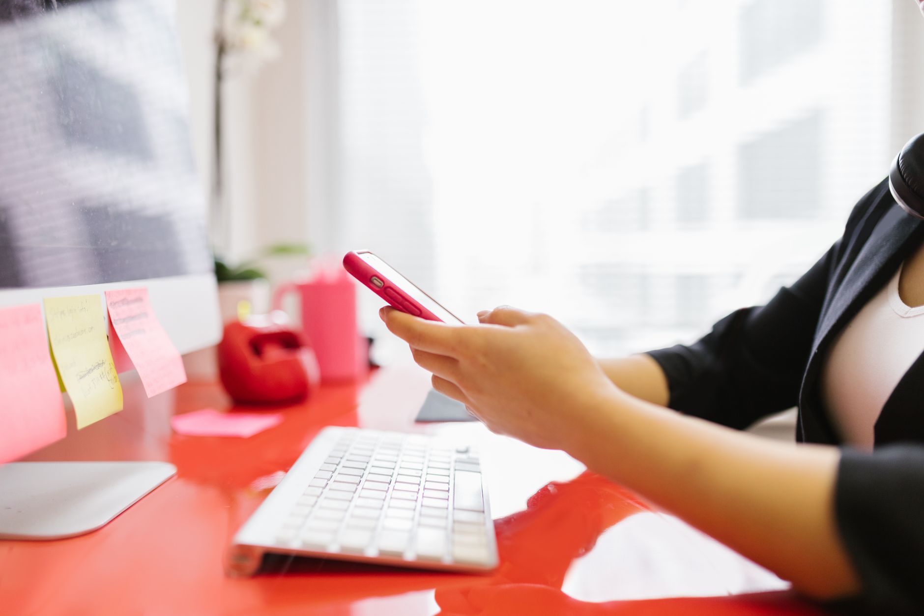 Professionnel consultant son téléphone portable à un poste de travail de bureau moderne.